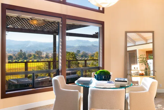 a dining room with furniture water view and a floor to ceiling window