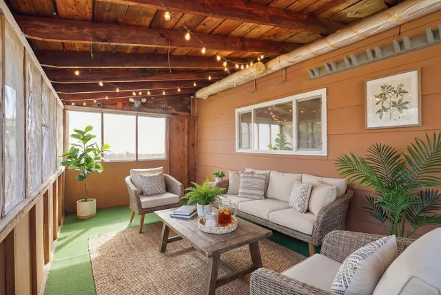 a living room with patio furniture and a potted plant