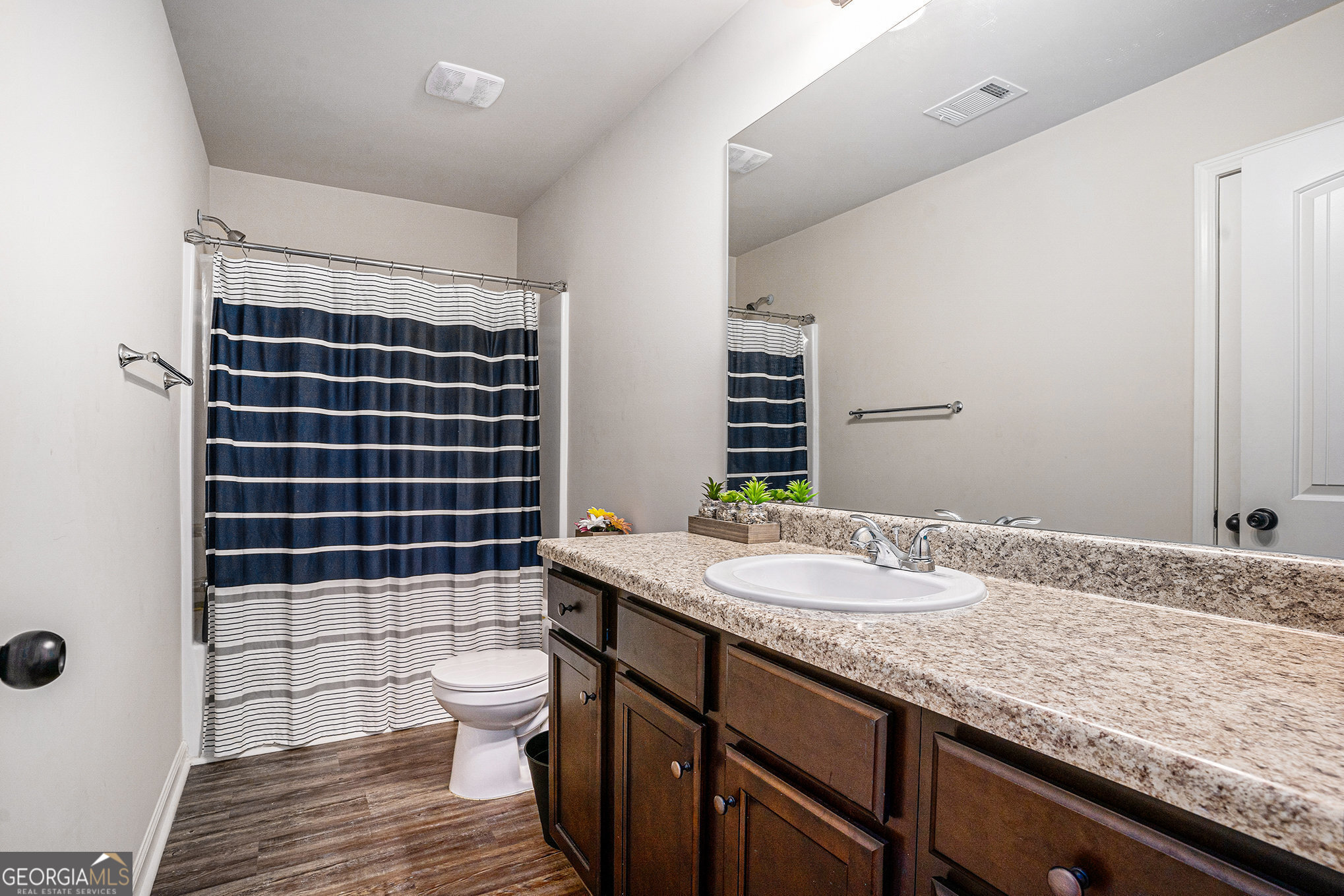 121 Amelia Way Ellenwood, GA 30294 - Photo 30 of 31 a bathroom with a granite countertop sink a toilet a mirror and shower