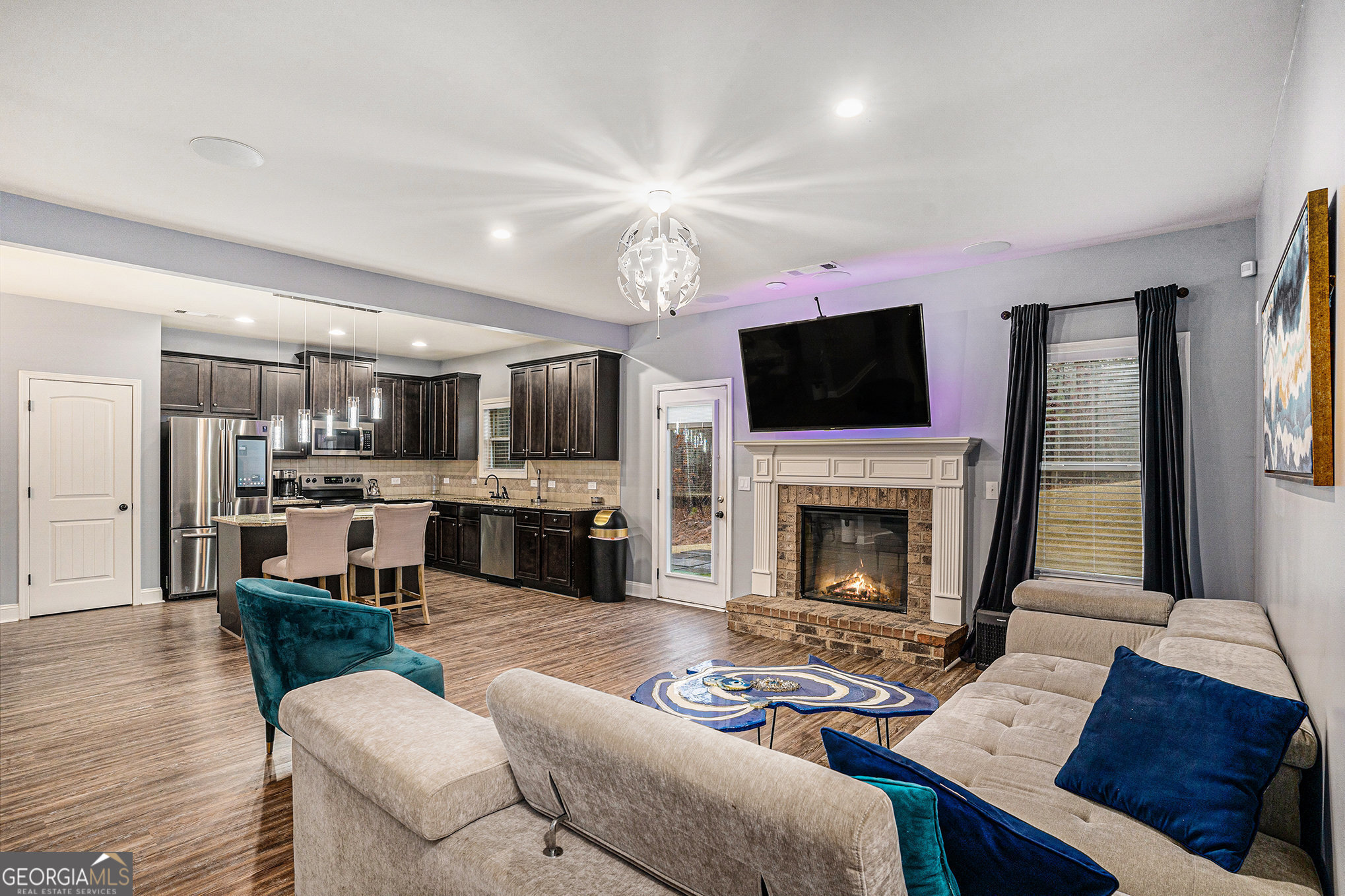 121 Amelia Way Ellenwood, GA 30294 - Photo 6 of 31 a living room with furniture a fireplace and a flat screen tv