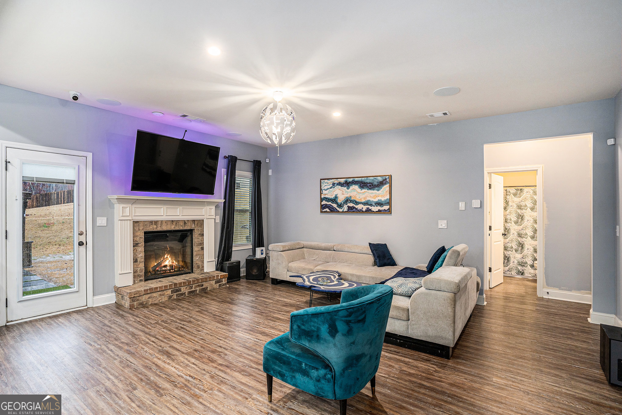 121 Amelia Way Ellenwood, GA 30294 - Photo 8 of 31 a living room with furniture a flat screen tv and a fireplace