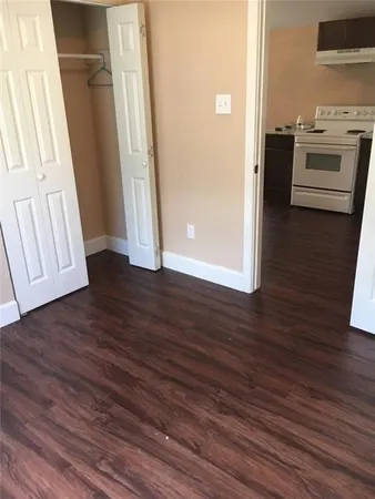an empty room with wooden floor and electronic appliances