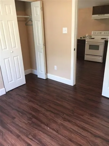 an empty room with wooden floor and electronic appliances