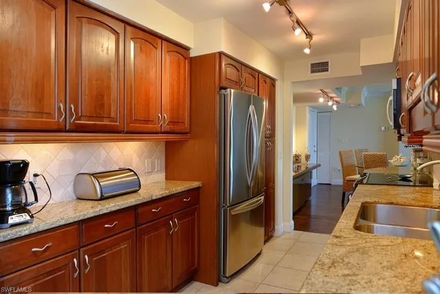 a kitchen with stainless steel appliances granite countertop a refrigerator and a sink