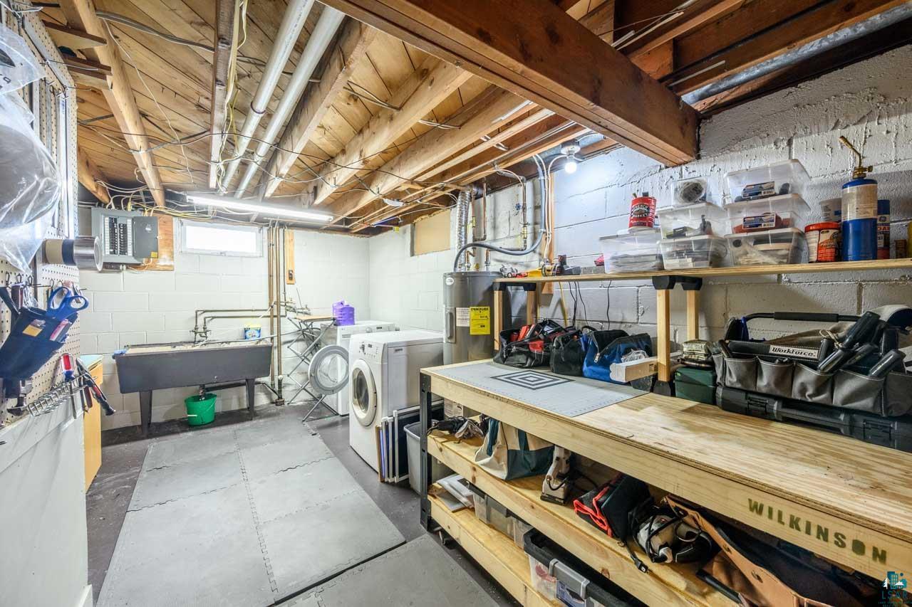 301 2nd Street North Biwabik, MN 55708 - Photo 26 of 43 Lower-level utility area featuring exposed joist ceiling, concrete block walls, a utility sink, and built-in shelving