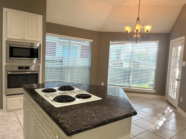 a kitchen with a stove and a wooden floor