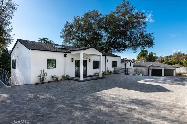 a white house with a large tree in front of it
