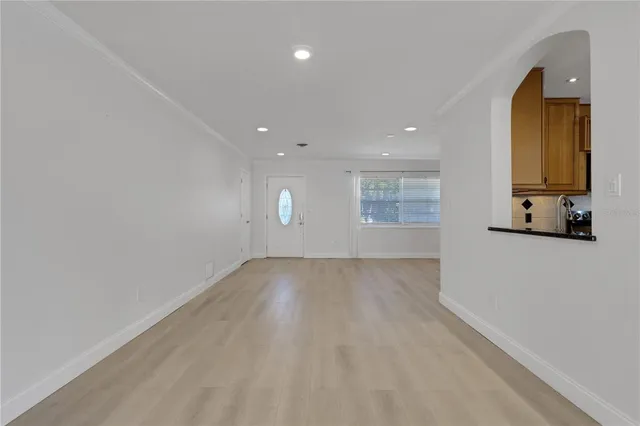 an empty room with a window and wooden floor
