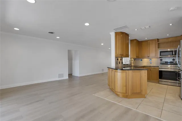 a kitchen with stainless steel appliances granite countertop a stove a sink and a refrigerator