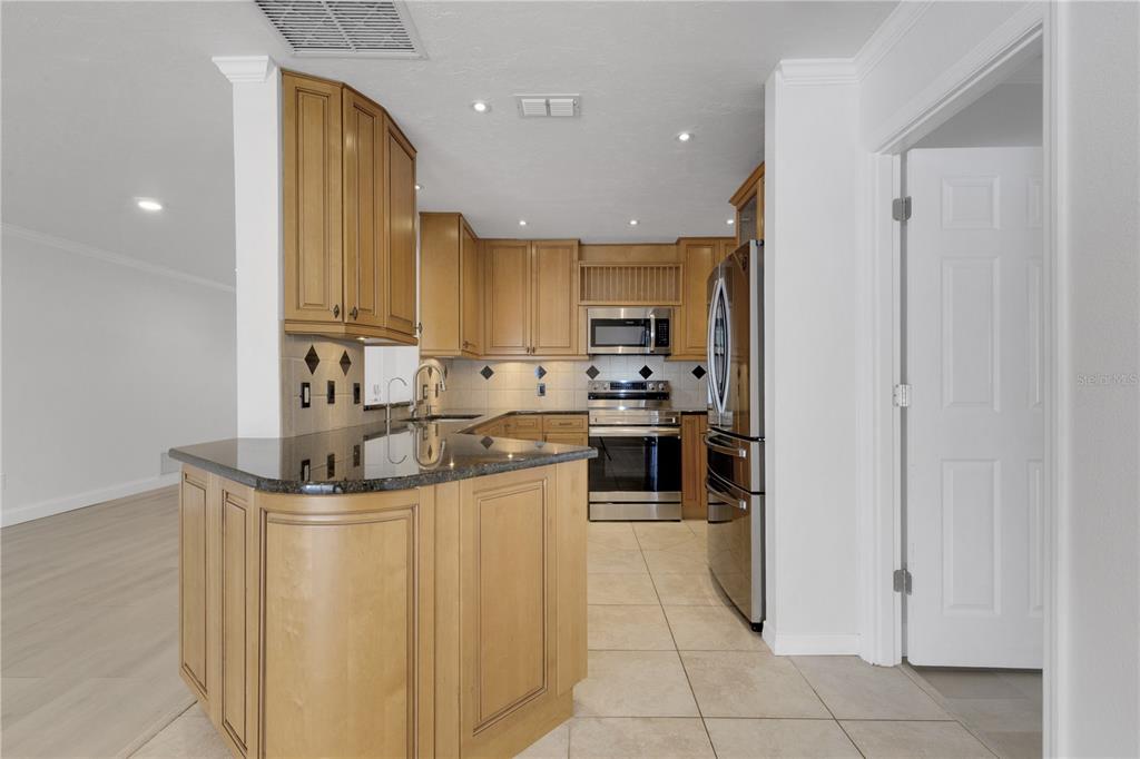 3856 Tarpon Road Venice, FL 34293 - Photo 18 of 53 a kitchen with stainless steel appliances granite countertop a sink a stove and a refrigerator