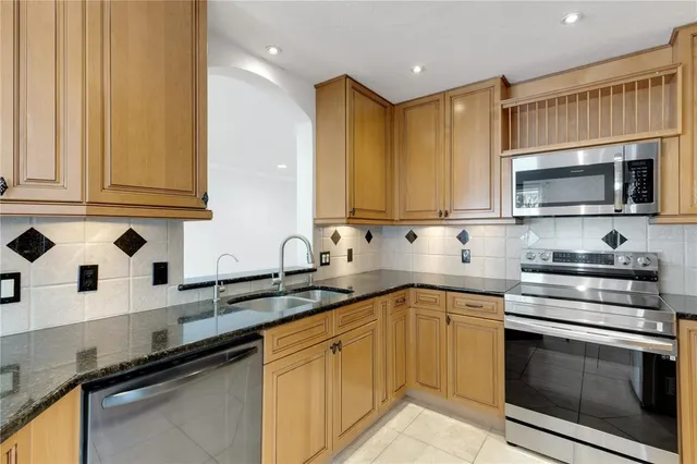 a kitchen with stainless steel appliances granite countertop a sink stove and microwave