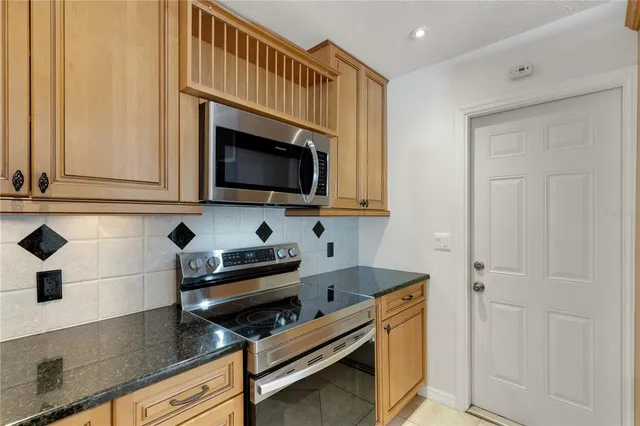 a kitchen with stainless steel appliances a stove microwave and sink
