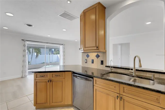 a kitchen with stainless steel appliances granite countertop a sink and cabinets with wooden floor