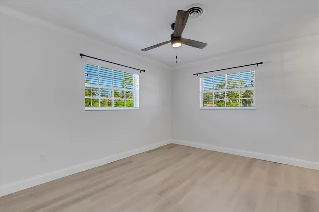 a view of an empty room with a window and a ceiling fan
