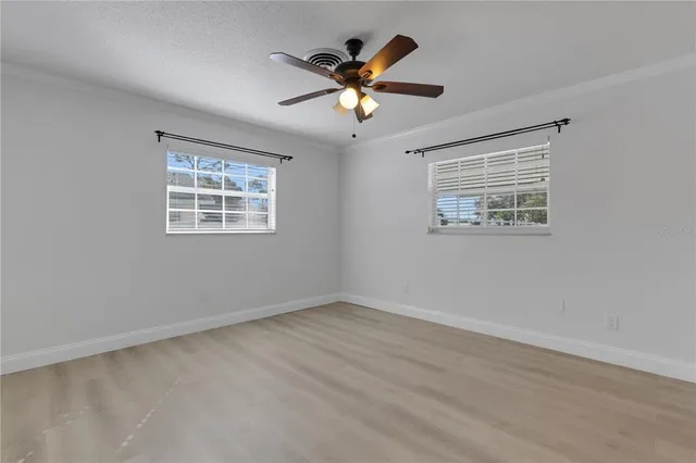 a view of an empty room with a ceiling fan and a window