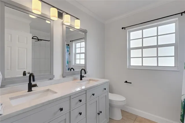 a bathroom with a double vanity sink toilet and a mirror