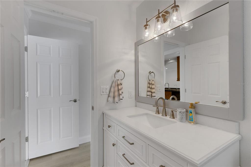 3856 Tarpon Road Venice, FL 34293 - Photo 41 of 53 a bathroom with a sink vanity granite and a mirror