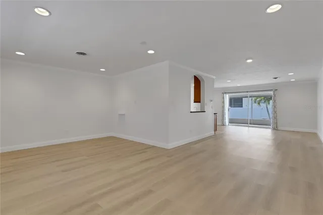 a view of empty room with wooden floor and window