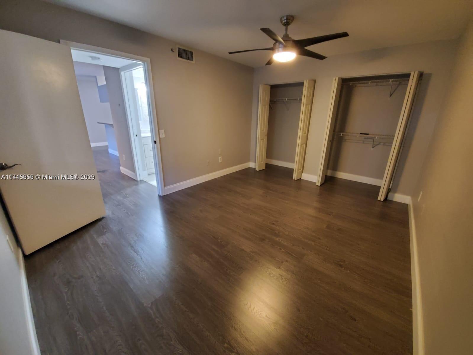 420 South Park Road, Unit 2110 Hollywood, FL 33021 - Photo 11 of 15 an empty room with wooden floor and a ceiling fan