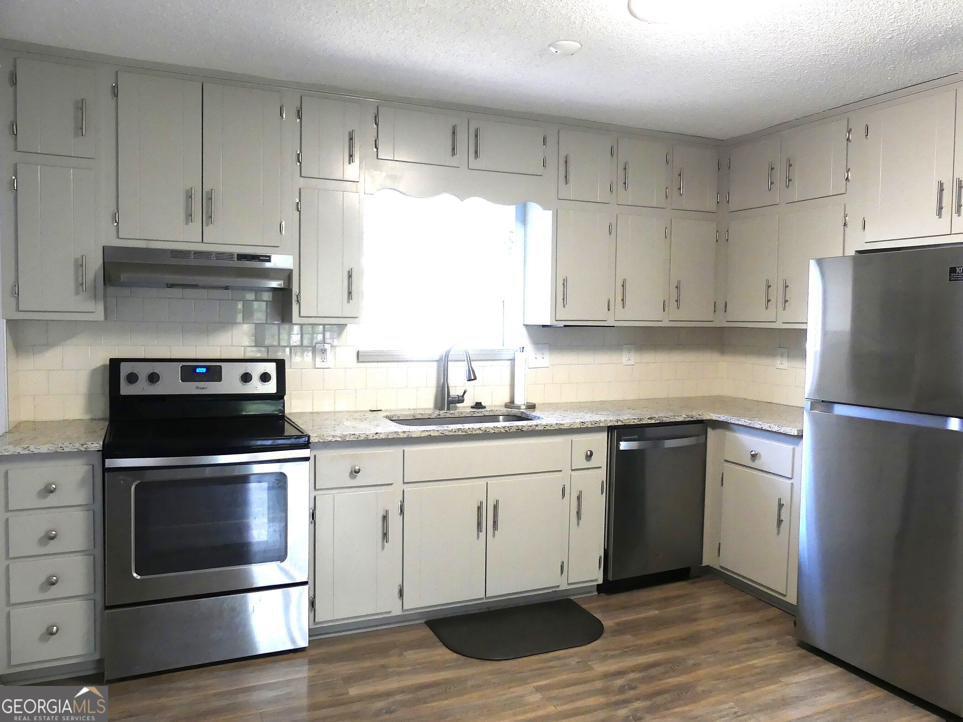 185 Stancil Drive Toccoa, GA 30577 - Photo 12 of 36 a kitchen with granite countertop white cabinets and stainless steel appliances