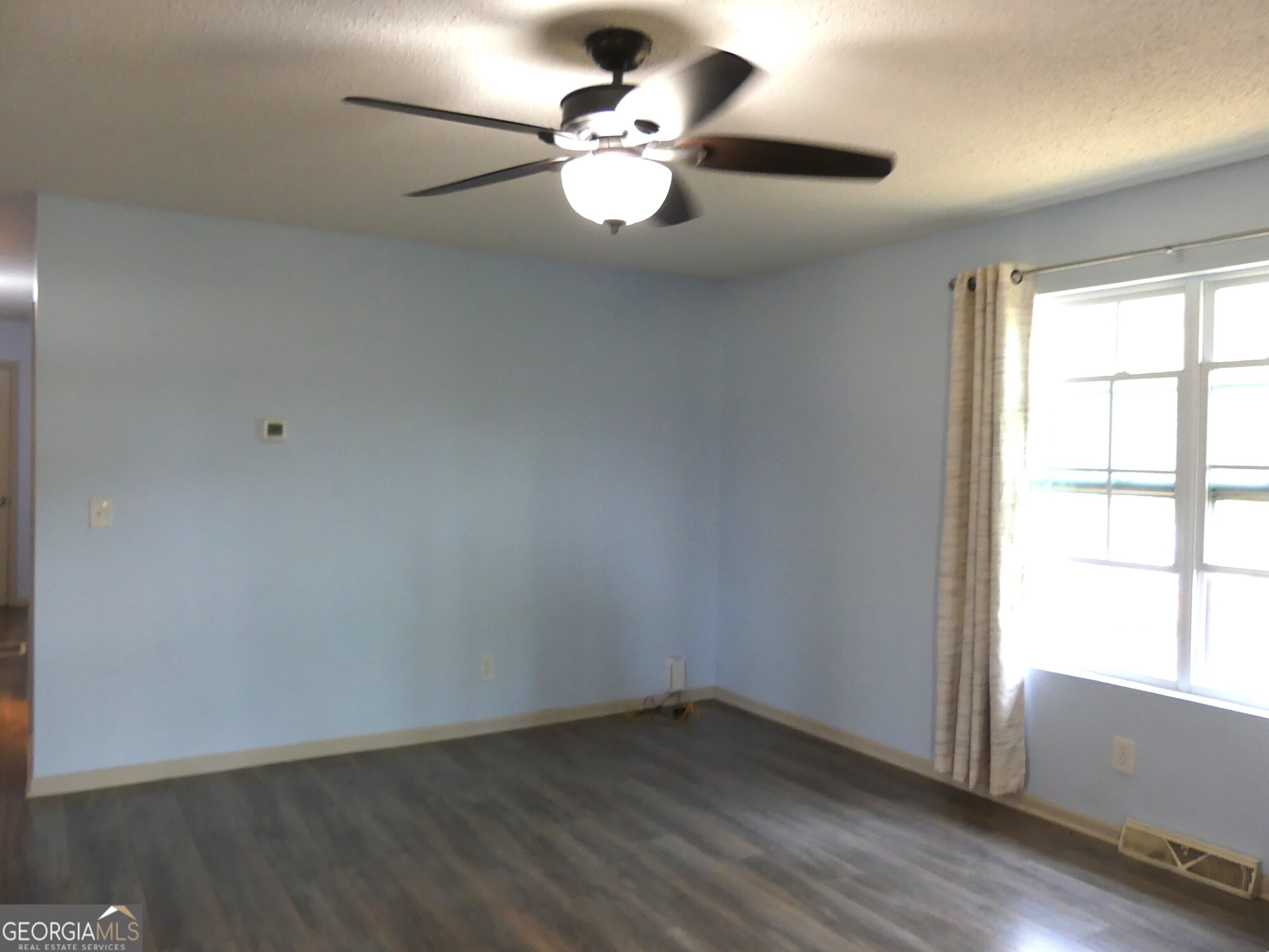 185 Stancil Drive Toccoa, GA 30577 - Photo 19 of 36 an empty room with wooden floor fan and windows