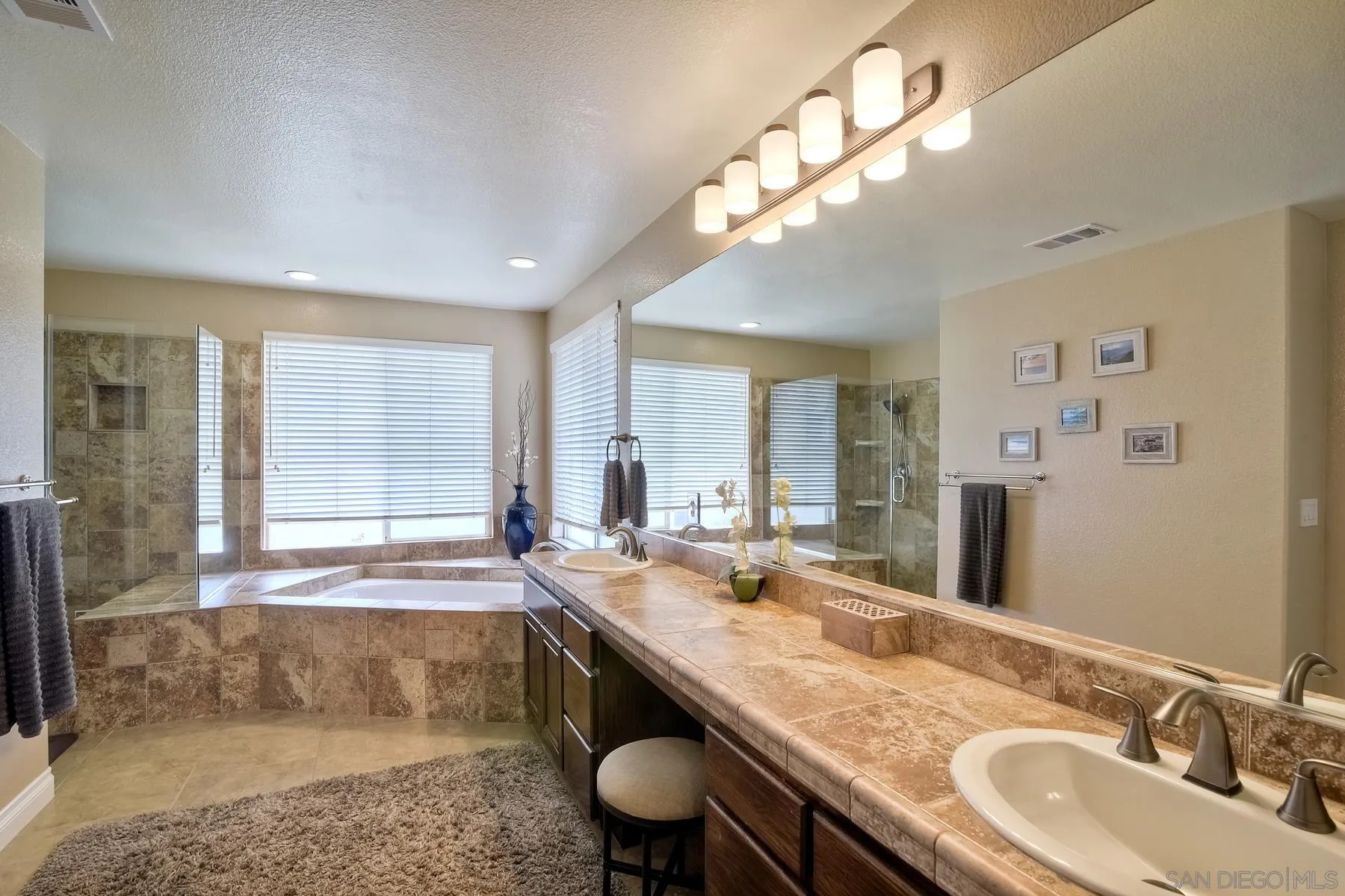 3670 Sutter Court Oceanside, CA 92056 - Photo 22 of 43 a bathroom with a granite countertop sink a large mirror and a bathtub