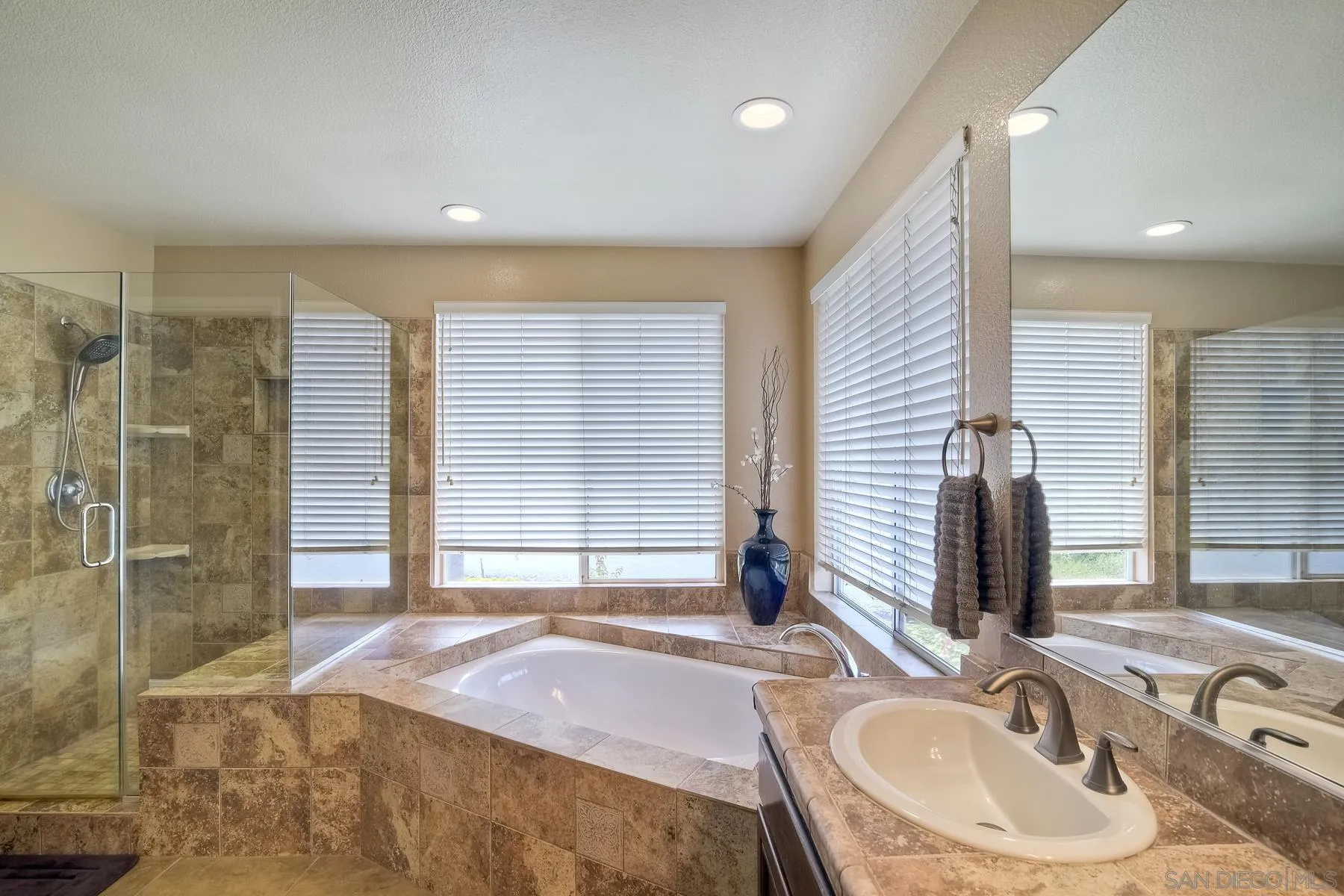 3670 Sutter Court Oceanside, CA 92056 - Photo 23 of 43 a spacious bathroom with a granite countertop sink and a mirror
