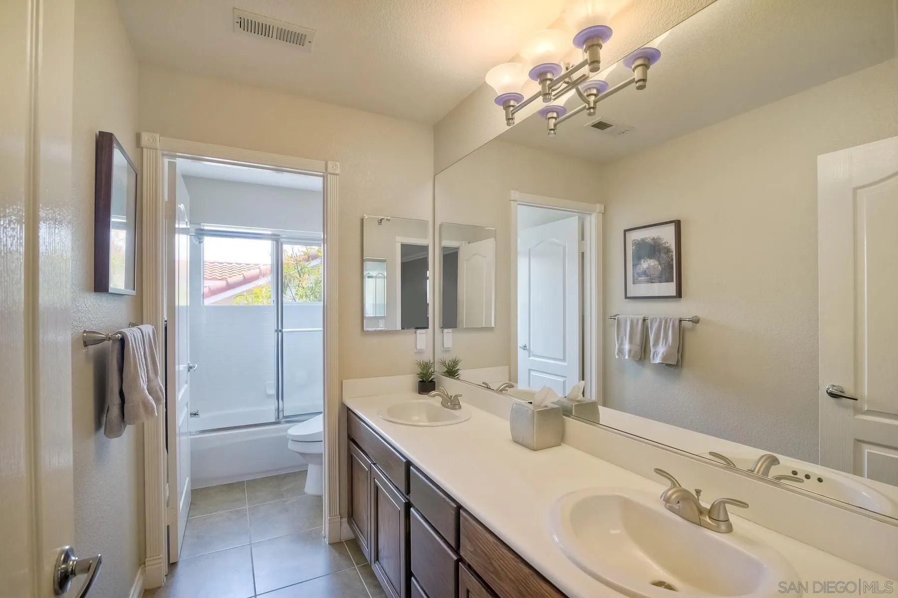 3670 Sutter Court Oceanside, CA 92056 - Photo 26 of 43 a bathroom with a double vanity sink and a mirror