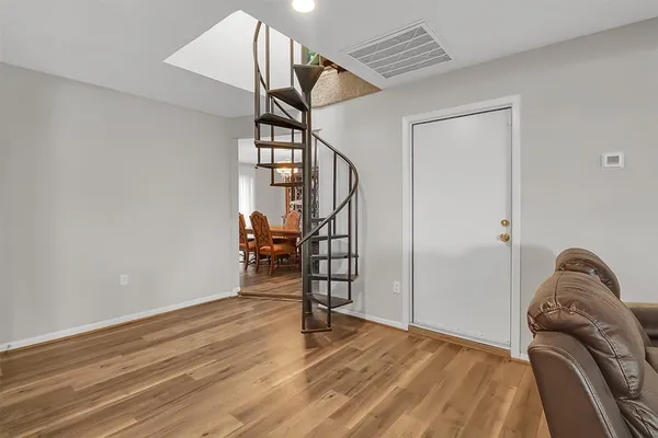 a view of empty room with stairs and wooden floor