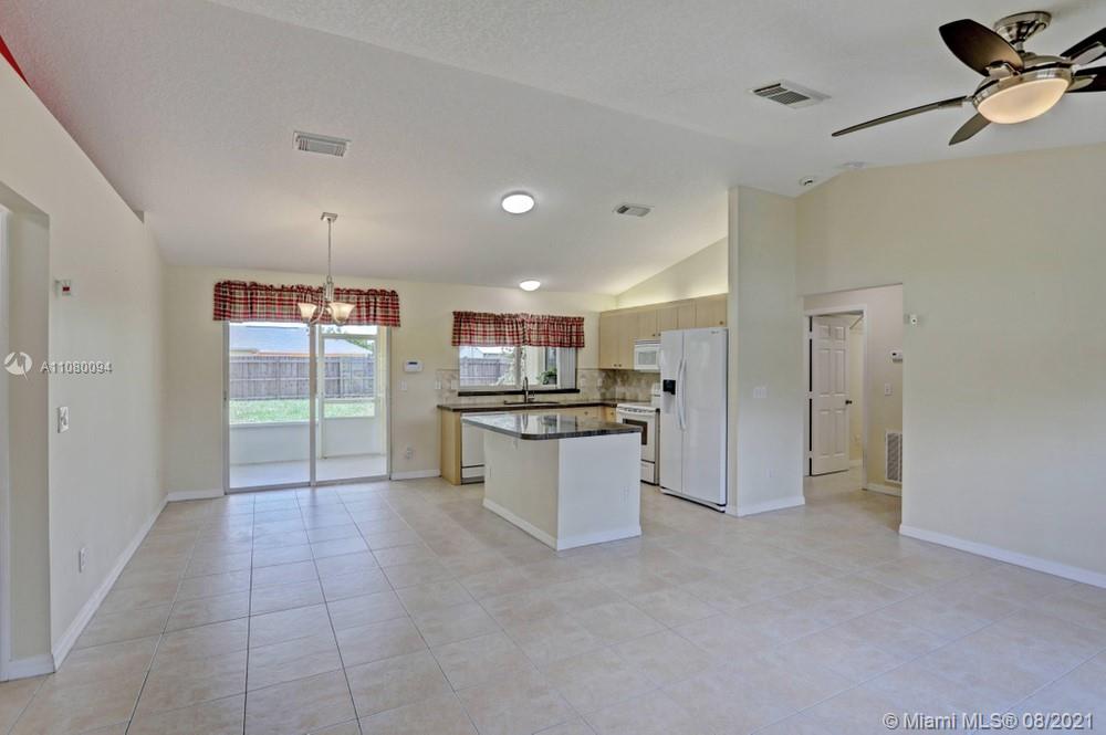 918 Southwest Longfellow Road, Unit 918 Port St. Lucie, FL 34953 - Photo 13 of 53 a large kitchen with a refrigerator and white cabinets