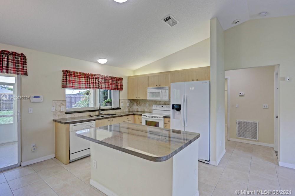 918 Southwest Longfellow Road, Unit 918 Port St. Lucie, FL 34953 - Photo 14 of 53 a kitchen with stainless steel appliances granite countertop a sink and refrigerator