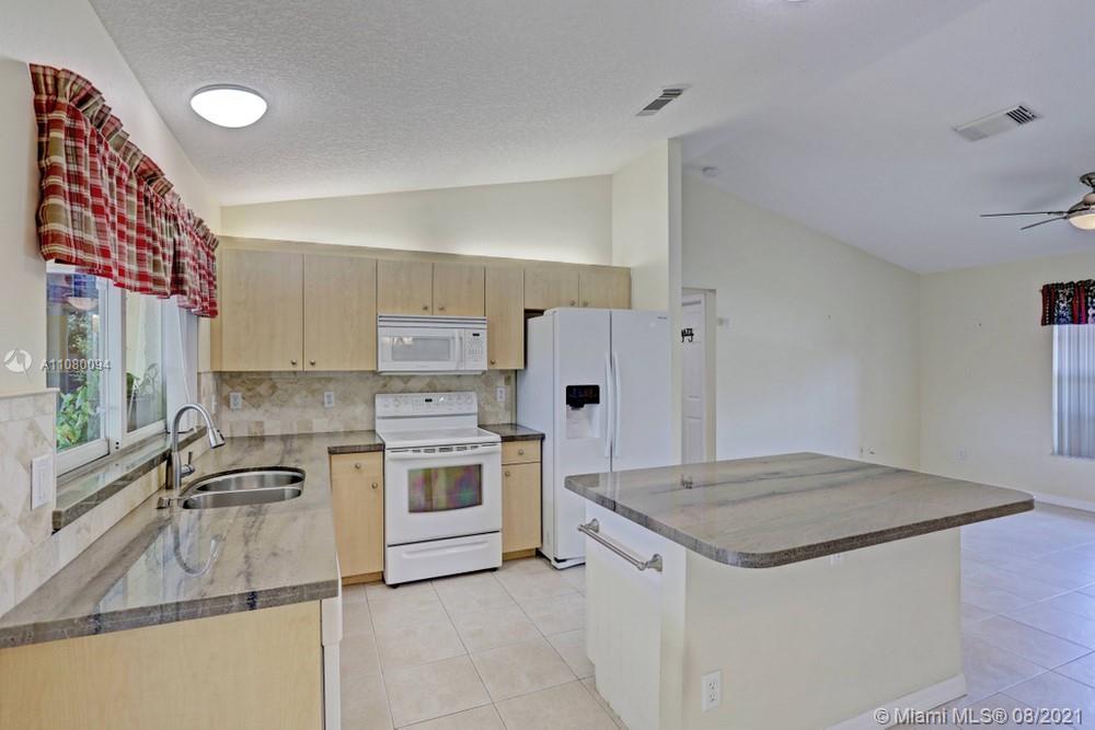 918 Southwest Longfellow Road, Unit 918 Port St. Lucie, FL 34953 - Photo 15 of 53 a kitchen with a stove a sink and a refrigerator