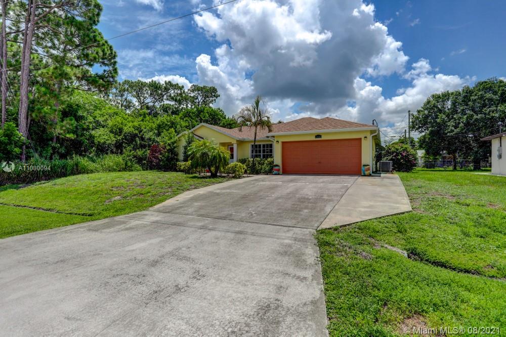 918 Southwest Longfellow Road, Unit 918 Port St. Lucie, FL 34953 - Photo 3 of 53 a front view of a house with yard and green space