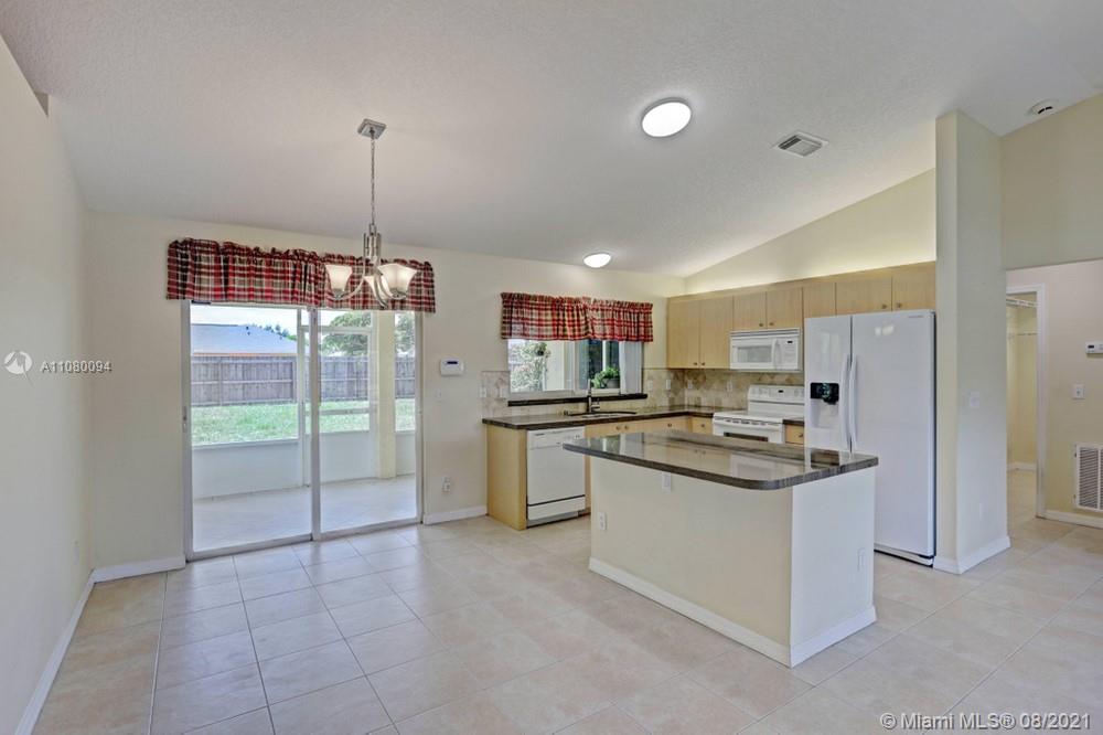 918 Southwest Longfellow Road, Unit 918 Port St. Lucie, FL 34953 - Photo 21 of 53 a kitchen with kitchen island a sink stainless steel appliances and cabinets