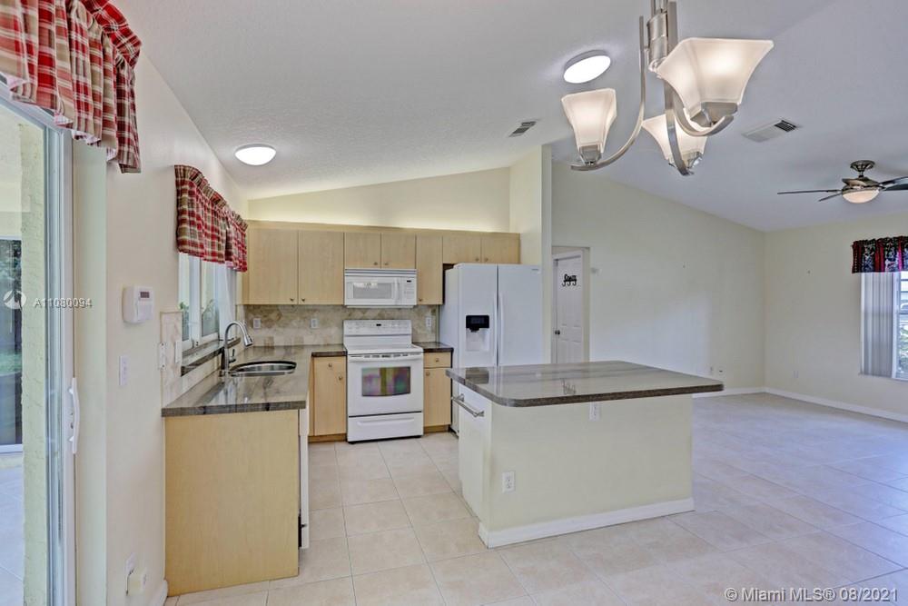 918 Southwest Longfellow Road, Unit 918 Port St. Lucie, FL 34953 - Photo 23 of 53 a kitchen with kitchen island a sink appliances and cabinets