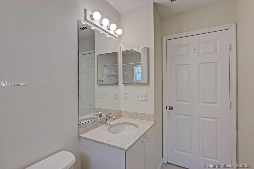 918 Southwest Longfellow Road, Unit 918 Port St. Lucie, FL 34953 - Photo 31 of 53 a bathroom with a toilet sink and mirror