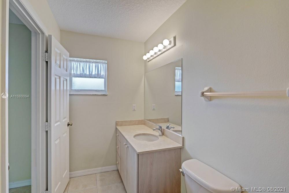 918 Southwest Longfellow Road, Unit 918 Port St. Lucie, FL 34953 - Photo 38 of 53 a bathroom with a sink a toilet and shower