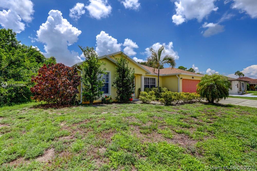 918 Southwest Longfellow Road, Unit 918 Port St. Lucie, FL 34953 - Photo 5 of 53 a view of a house with a big yard and large trees