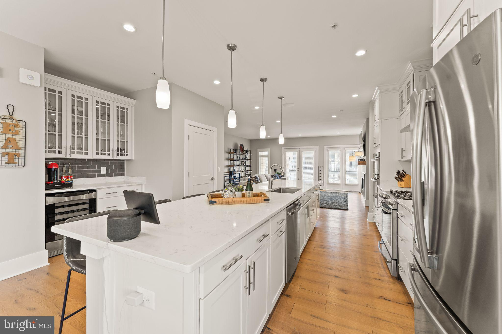 20052 Old Line Terrace Ashburn, VA 20147 - Photo 6 of 67 a kitchen with stainless steel appliances a stove oven a refrigerator a oven and white cabinets with wooden floor