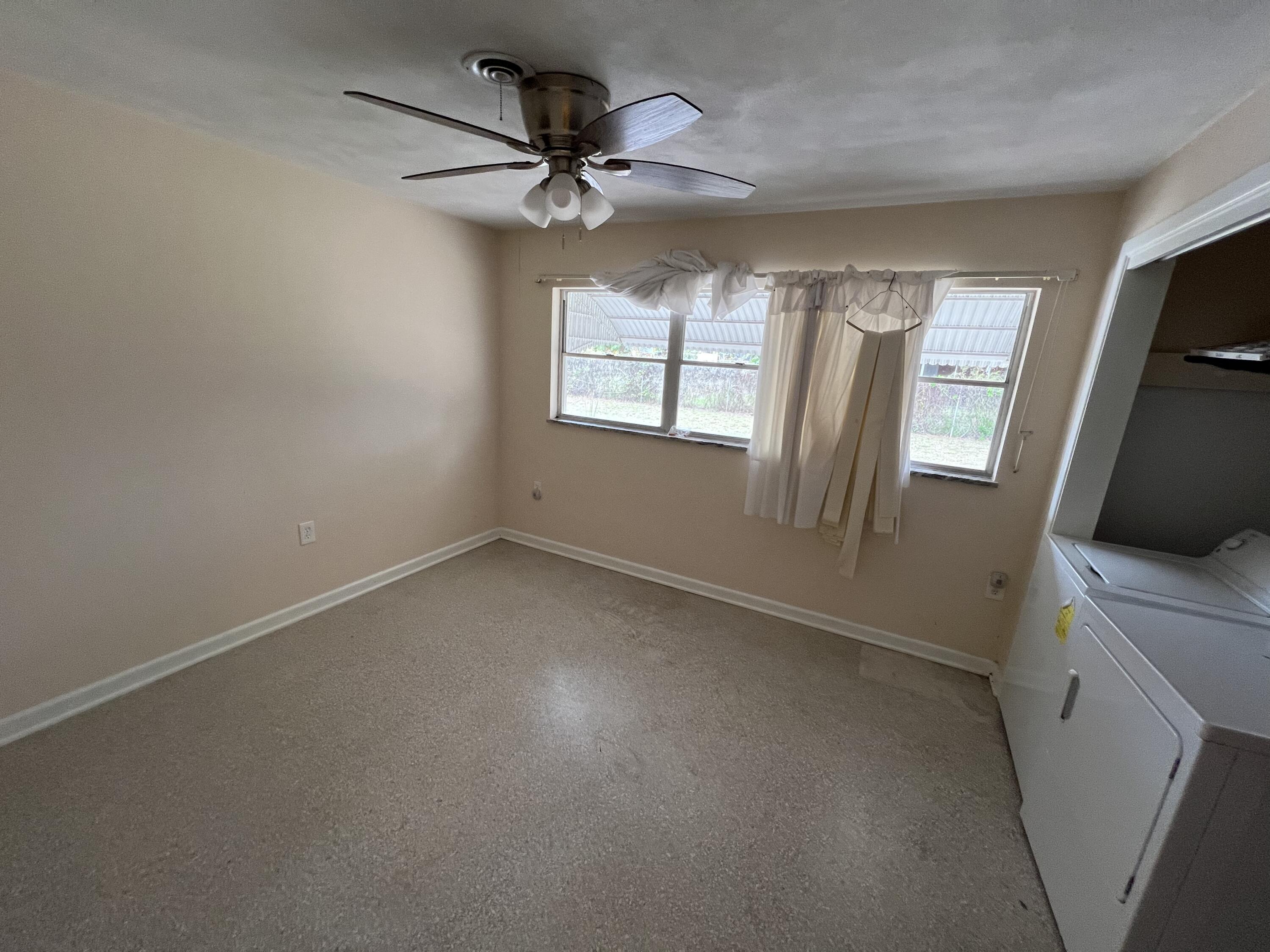 1908 Colonial Road Fort Pierce, FL 34950 - Photo 3 of 14 an empty room with windows and fan
