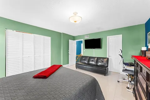 a bedroom with a bed and flat screen tv