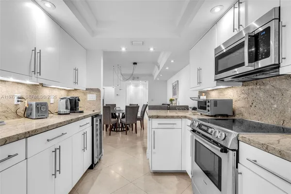 a kitchen with stainless steel appliances granite countertop a sink stove oven and white cabinets
