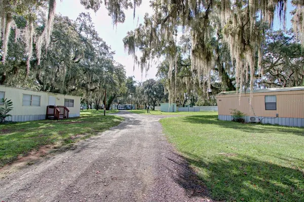 a view of a house with backyard and trees