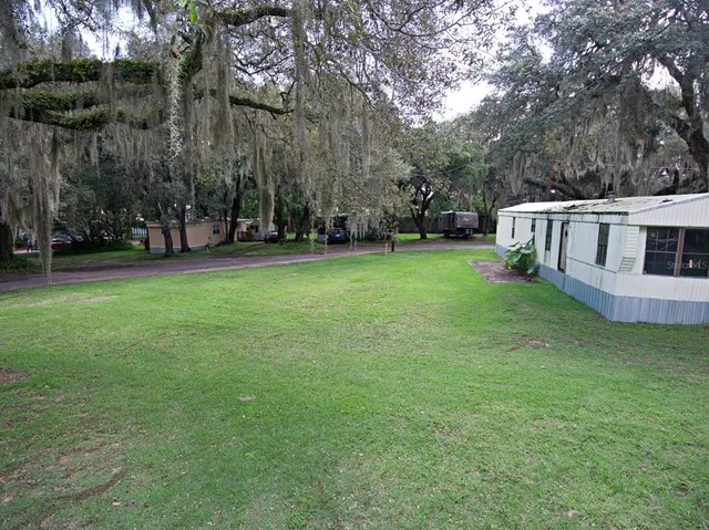 a view of a house with backyard and trees