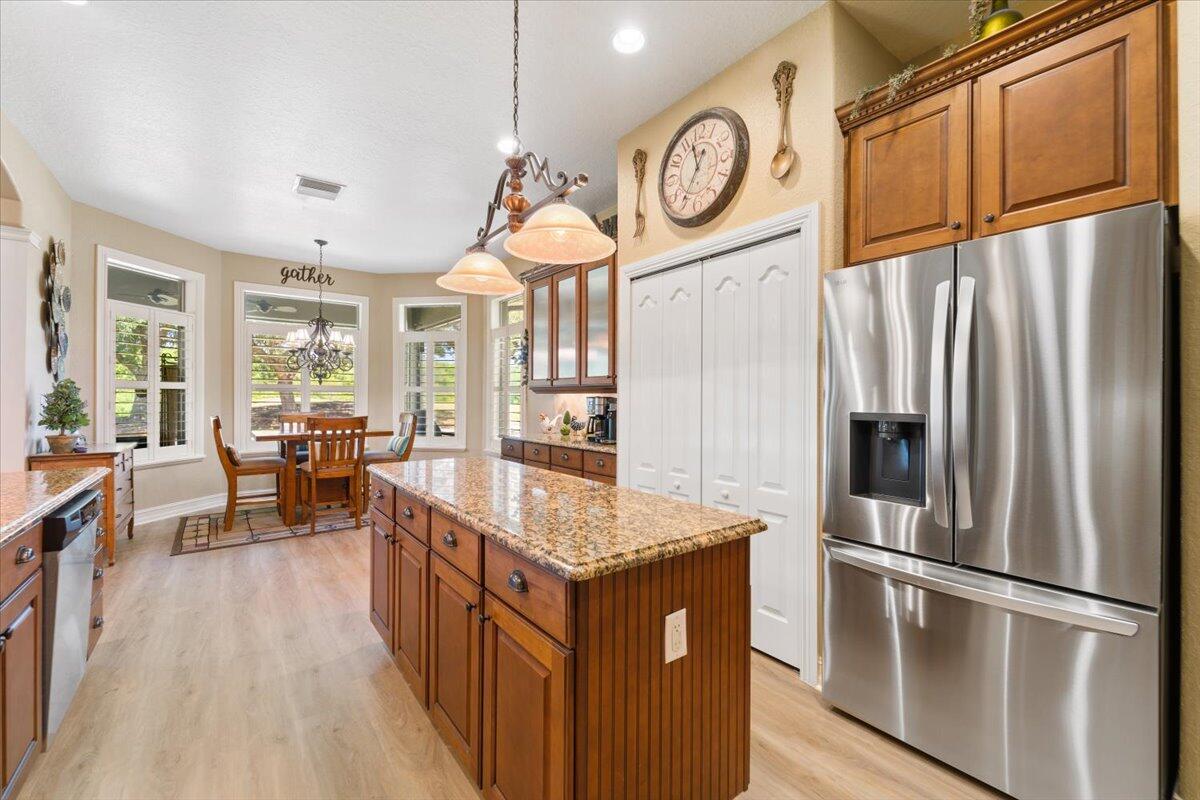 3260 Quantum Place Mims, FL 32754 - Photo 14 of 30 a kitchen with stainless steel appliances granite countertop a refrigerator a stove and a wooden floors