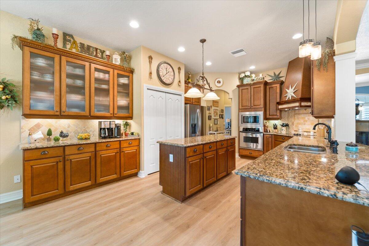 3260 Quantum Place Mims, FL 32754 - Photo 16 of 30 a large kitchen with stainless steel appliances granite countertop a stove and cabinets