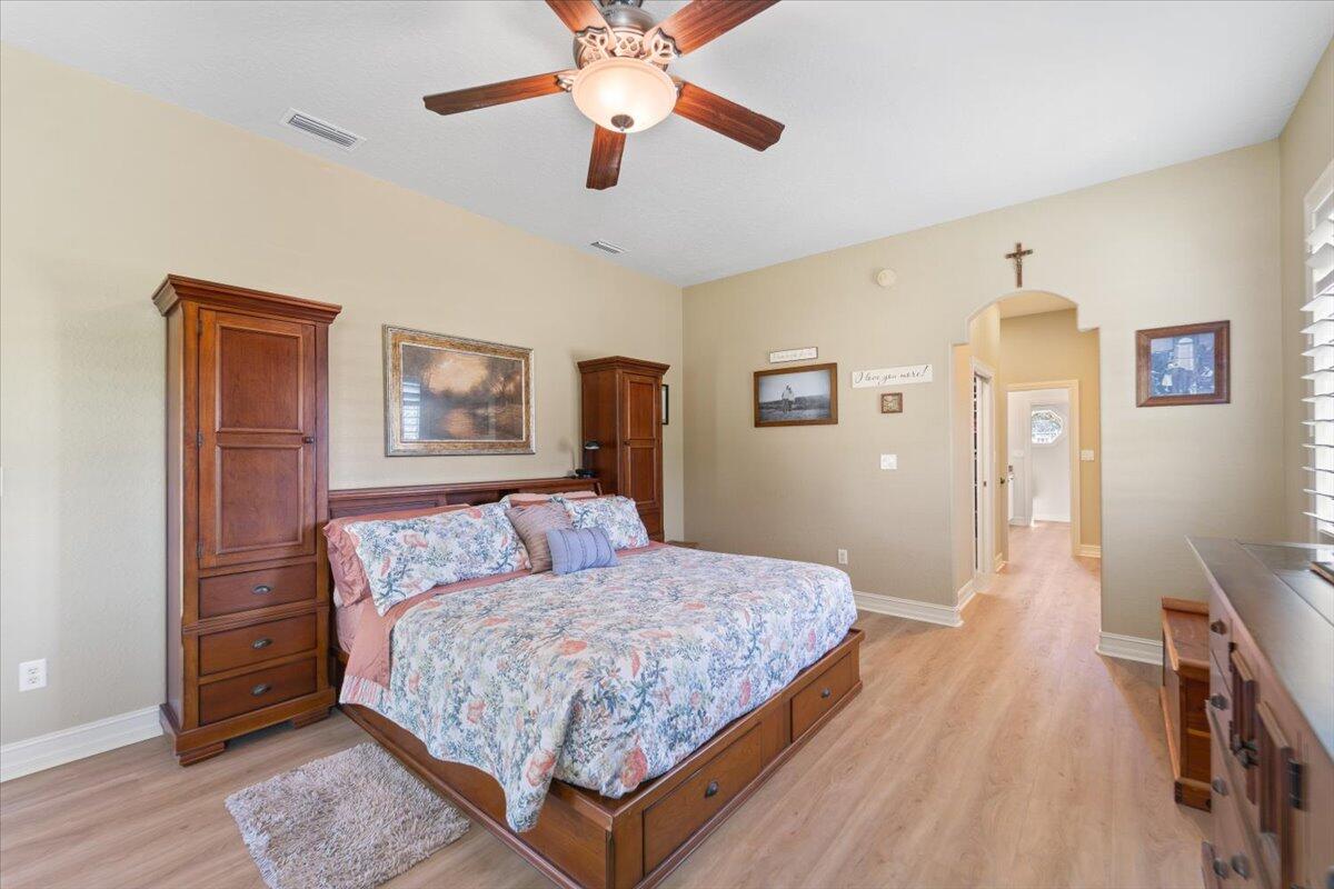 3260 Quantum Place Mims, FL 32754 - Photo 20 of 30 a bedroom with a large bed a chandelier and dresser