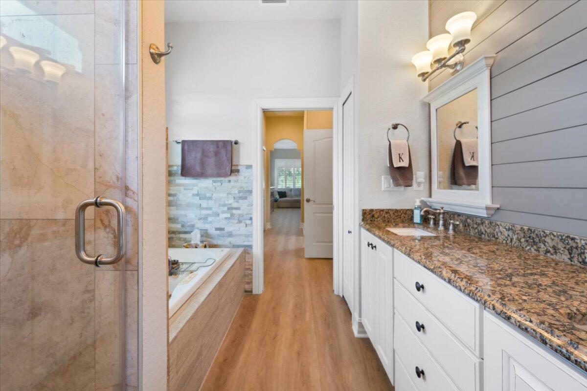 3260 Quantum Place Mims, FL 32754 - Photo 23 of 30 a bathroom with a granite countertop sink a mirror a vanity and bathtub