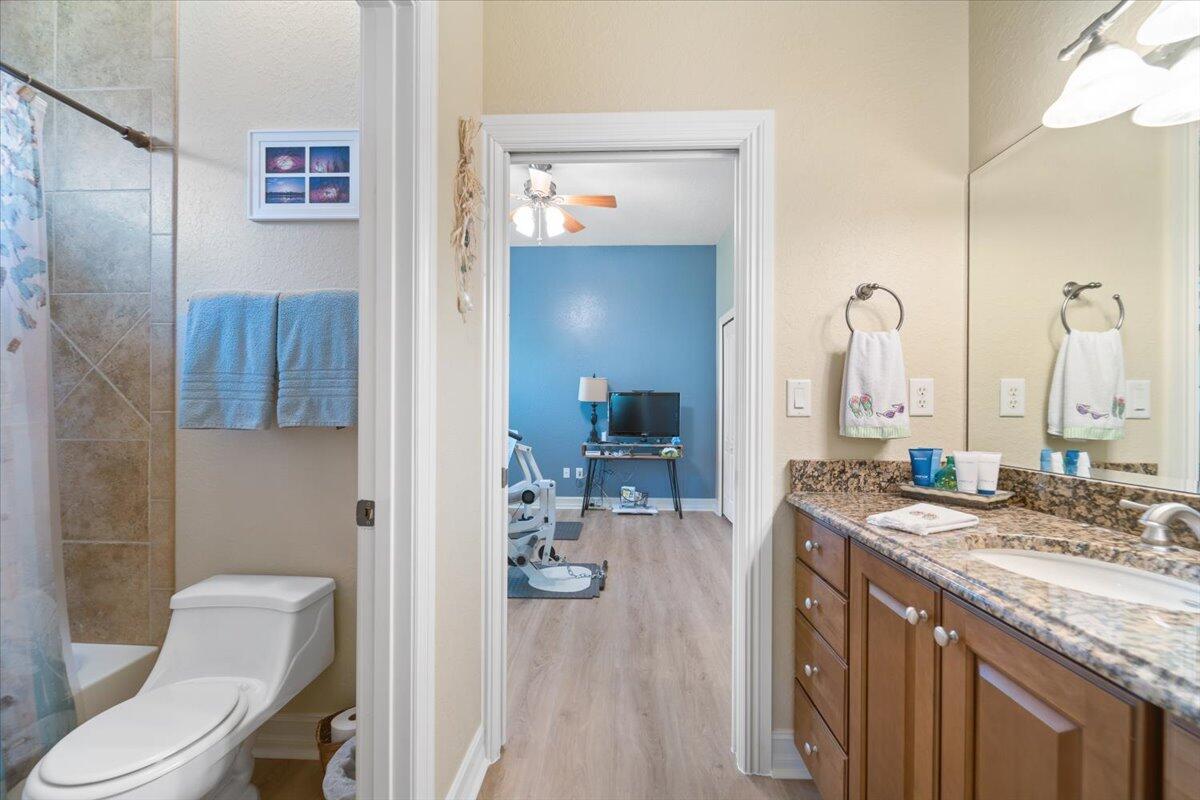 3260 Quantum Place Mims, FL 32754 - Photo 26 of 30 a bathroom with a granite countertop sink a toilet and a mirror
