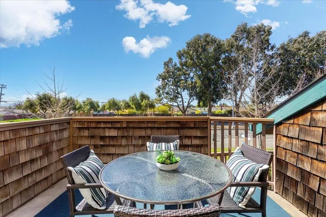 a view of a balcony with dining table and chairs